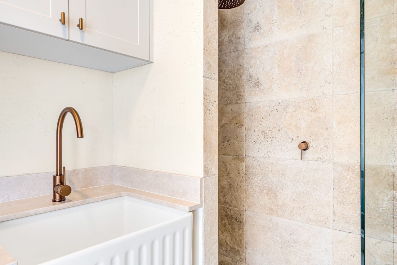 Copper gooseneck tap over the butler's sink, travertine shower behind, Mount Riverview