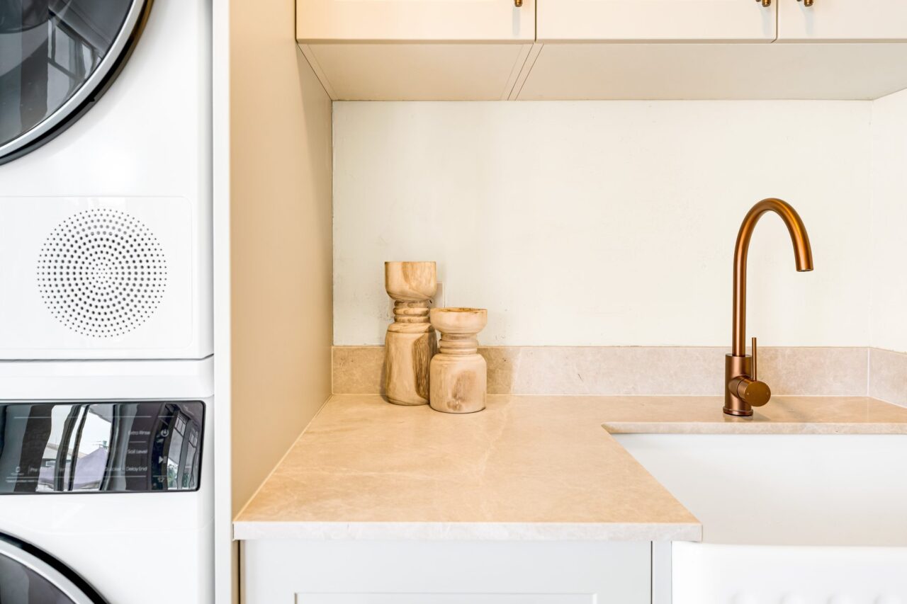 Copper tap and stone benchtop beside the stacked dryer, Mount Riverview