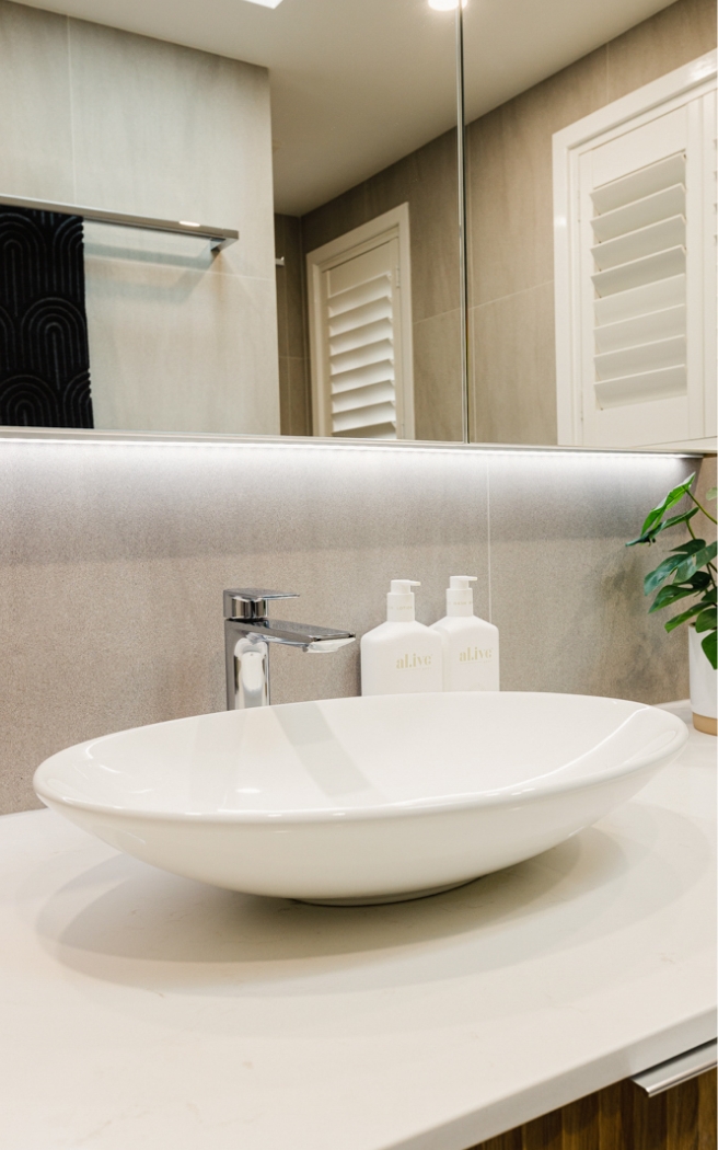 Bathroom vanity with oval basin, stone benchtop and full-width mirror